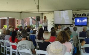 author Susan Scott on stage and back of people in audience